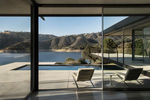 The pool terrace off the living room, hills across the reservoir.